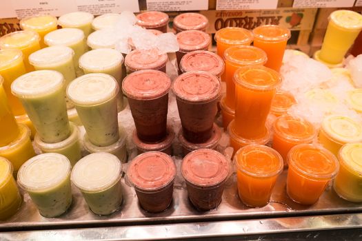 Colorful glasses of fresh fruit juice displayed at the Mercado de La Boqueria in Barcelona. The Mercat de Sant Josep de la Boqueria, often simply referred to as La Boqueria is a large public market in the Ciutat Vella district of Barcelona, Catalonia, Spain and one of the city's foremost tourist landmarks. The market has a very diverse selection of goods.