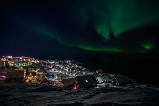 Greenlandic Northern lights over Inuit houses, Nuuk city