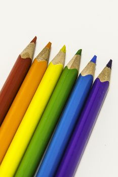 Colored crayons on the white background, school