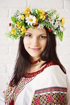 Portrait of a beautiful young girl in Ukrainian national dress and a wreath of flowers