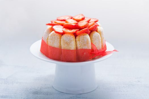 Yogurt strawberry cake with savoiardi biscuits on a plate