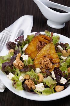 Salad of lettuce with   walnuts, cashews, slices  feta,  halves of caramelized pear