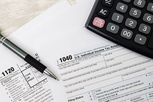 US tax form 1040 with pen and calculator. tax form law document usa white mathematics business concept