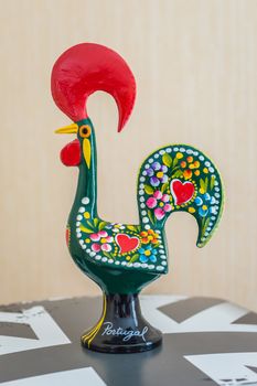 figure of wooden rooster carved in Portugal on a background of wall