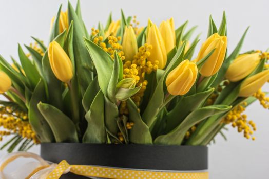 Bright spring bouquet of tulips and mimosa flowers. Mother's Day or Easter theme.