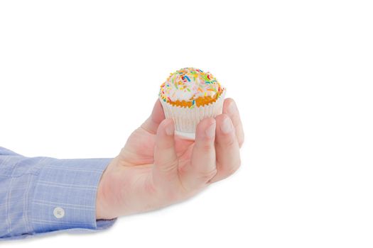 Little Easter muffin decorated with white icing and colorful sugar decors in male hand on a light background
