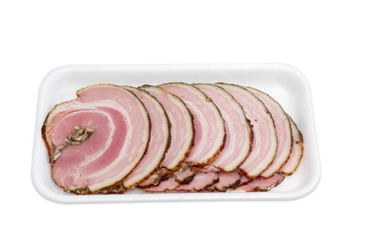 Sliced roll of a baked pork belly with layers of muscle and fats on a plastic tray on a light background 
