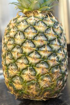 A closeup on a full green and yellow pineapple