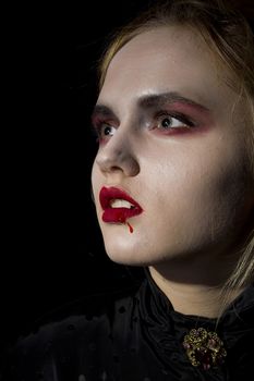 Young girl vampire on a black background