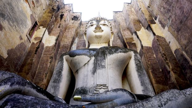 Historical Park Wat Sri chum temple bhudda statue worm eye view in Sukhothai world heritage