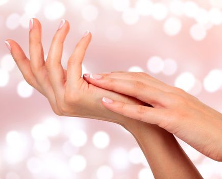 Beautiful woman hands against an abstract background with blurred lights