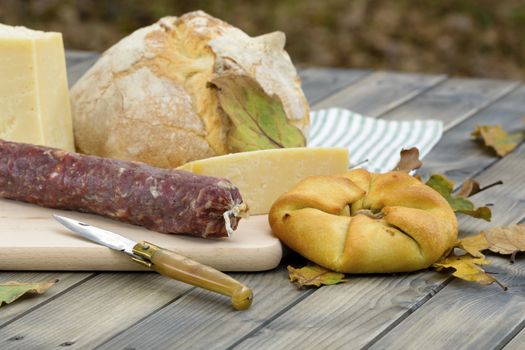 "Mustazzeddu" typical bread seasoned with tomato originally in Southern Sardinia. Cured sausage, bread and cheese