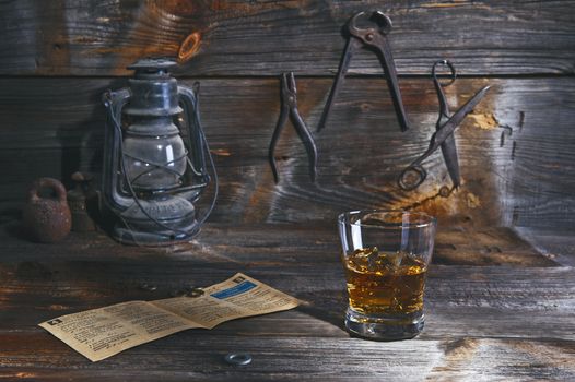 A glass of whiskey in an old wooden workshop