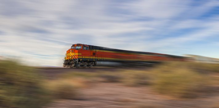Freight train ride at high speed through the desert