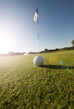 Image of a golfball on green by flag