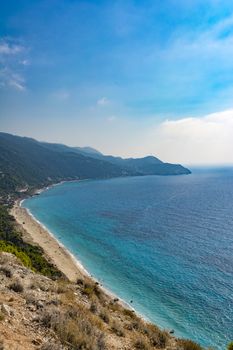 Lefkada island, Pefkoulia beach, Greece - August 30 2016: A large sandy beach, clean sea and pines all the way to the shore.