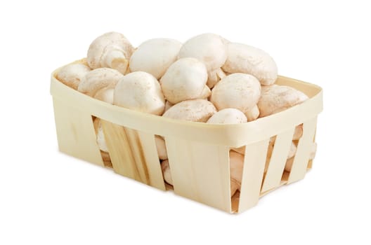 Fresh cultivated common button mushrooms in the wooden basket on a light background 
