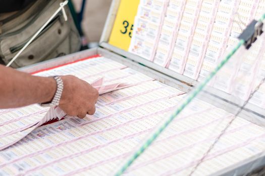 Man buying lottery at the counter. Thai lottery offers a form of entertainment for many people.