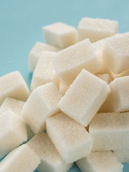Background of sugar cubes. White cube sugar on blue background. White sugar close up