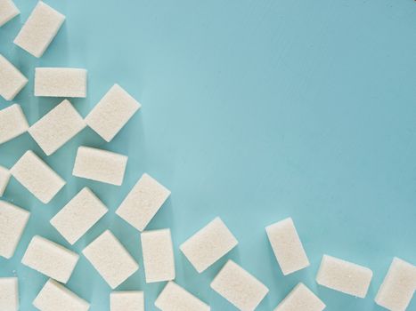 background of sugar cubes. White cube sugar on blue background. White sugar close up with copy space