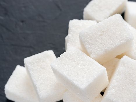 background of sugar cubes. White cube sugar on black background. White sugar close up with copy space