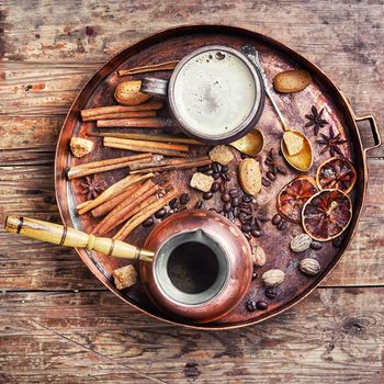 cezve and cup of coffee in copper tray with oriental spices