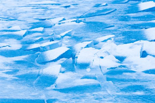 Winter scene at a frozen lake with ice-pack and other ice formations