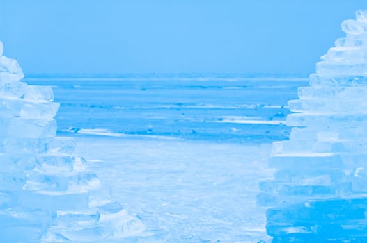 Winter scene at a frozen lake with towers made of ice bricks