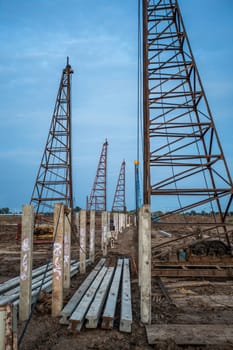 pile crane in construction site at sunset