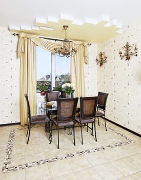 Dining table and chair in yellow kitchen with golden lamp