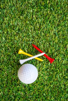 golf ball and tee on grass