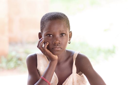 This girl sitting gaze to the camera and hand under chin , seems to be hungry.