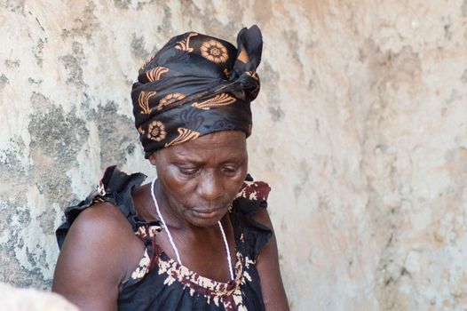 This woman is dressed like most African women living in the village. The head tied with a scarf and with a camisole loincloth