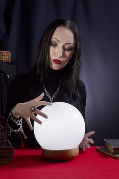 Fortune teller with a magic ball on a black background