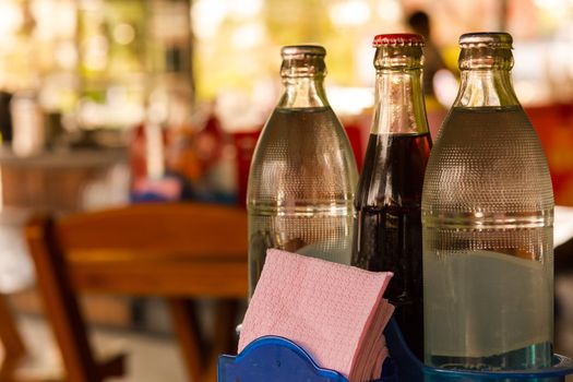 Water bottles and soft drink bottle and Tissues  papers on table and background restaurant in Asia.1
