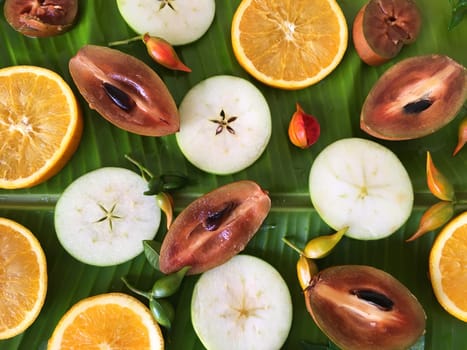 Tropical fruits sliced on the banana leaf. Viewed from top.