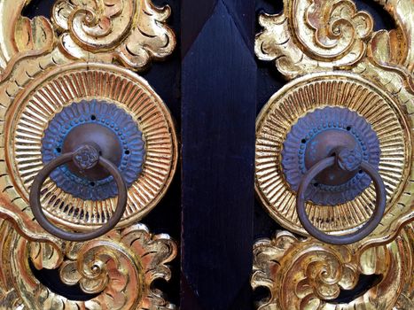 Asian style knobs door with beautiful design gold elements. Thailand knocker on wooden door.