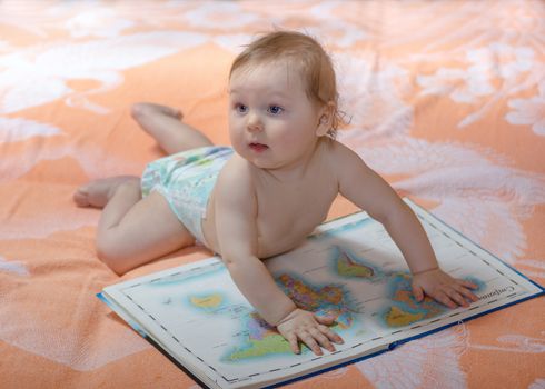 Small baby with big atlas maps of the world