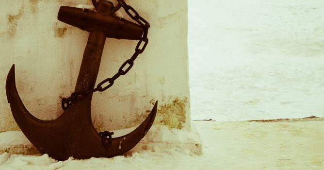 black anchor on a background of white snow retro photo