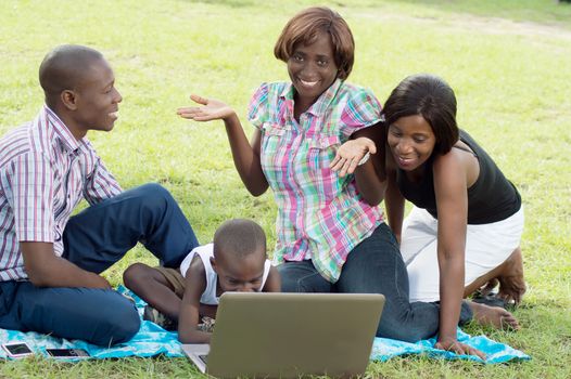 The child tap on the keyboard of the laptop , and one of the young women asks what he wants.
