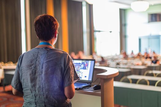 Female speaker giving talk at business conference. Audience at the conference hall. Business and entrepreneurship. Successful businesswoman concept. Horizontal composition.