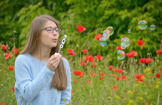 portrait of young girl with soap bubbles in forest