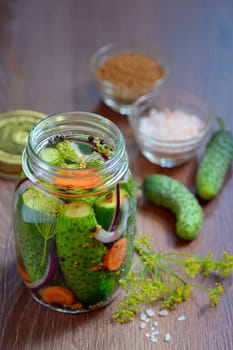 Pickled cucumbers, homemade preserved on wooden table