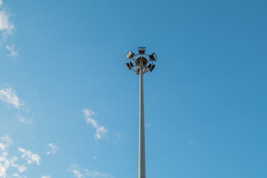 Pillar spotlights high on the blue sky