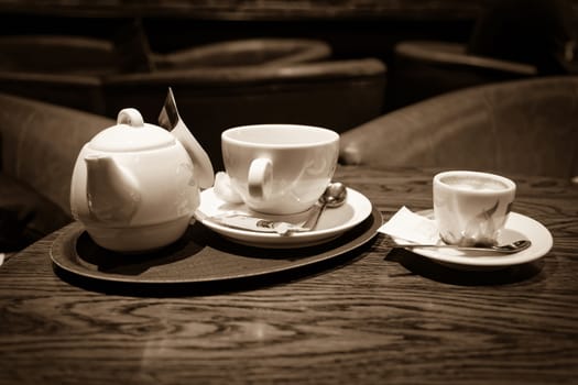 cup of coffee and tea on bar table, sepia toned