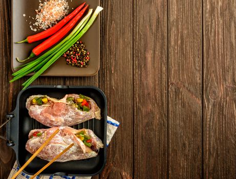 The chicken fillet and vegetables prepared for frying on a brown wooden background. Top view, copy space.