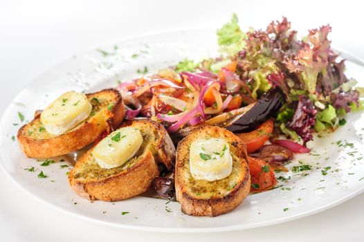 Grilled cheese on bread with salad of tomato, eggplants, red onion and lettuce