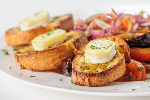 Grilled cheese on bread with salad of tomato, eggplants, red onion and lettuce, selective focus