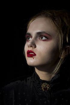 Young girl vampire on a black background