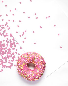 Creative concept photo of  a donut with hearts and card on white background.